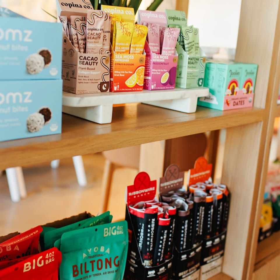 Drink mixes and packaged snacks on a market shelf.