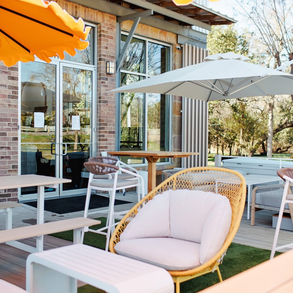 Outdoor patio seating beneath bright umbrellas.