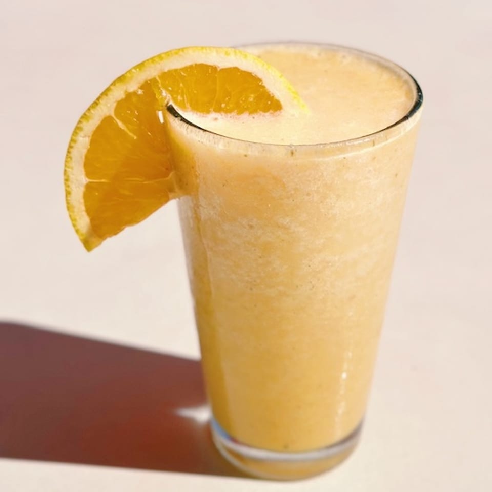 Sunrise drink garnished with an orange slice.